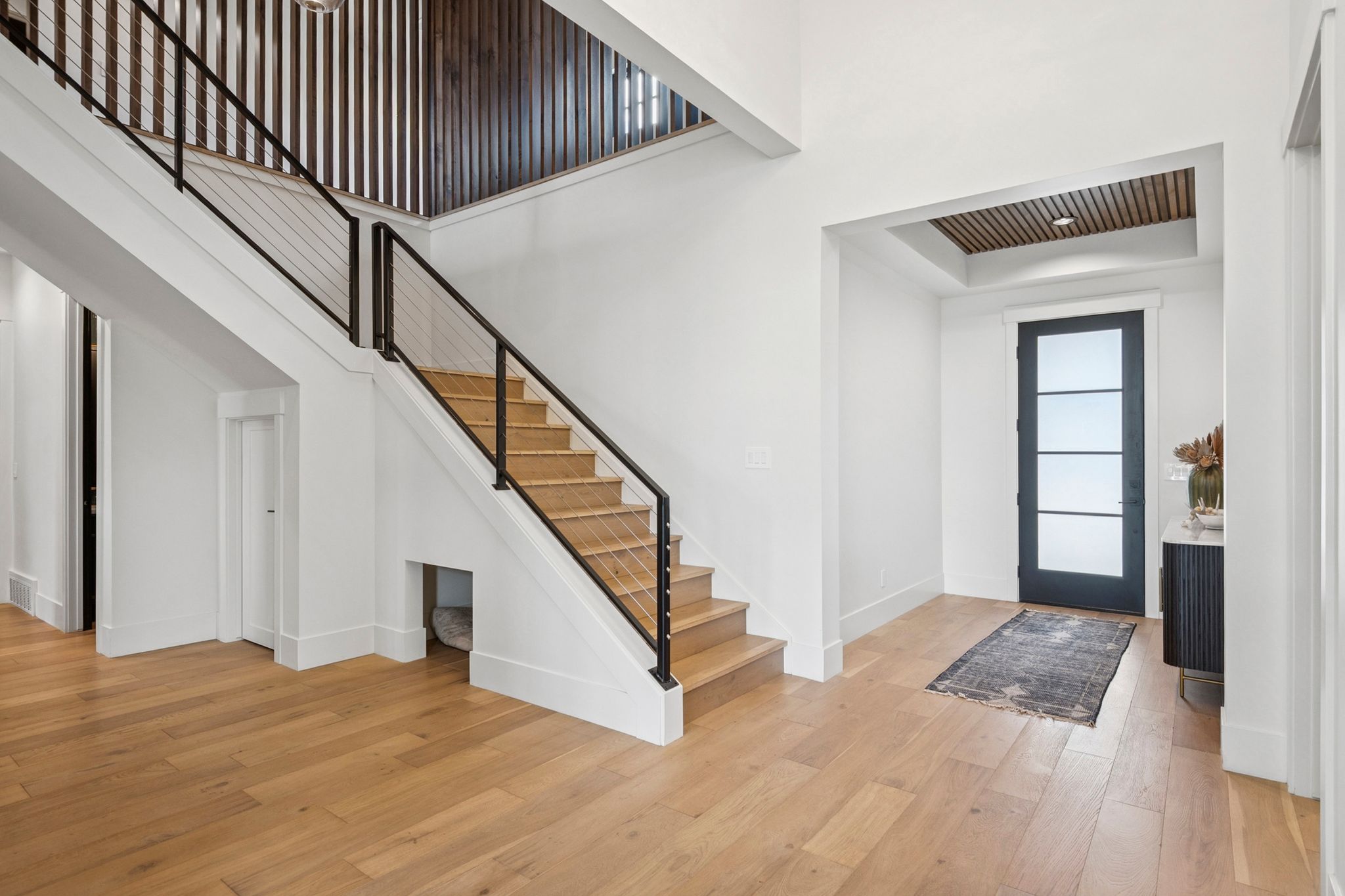 Slatted wood ceiling in entry with designer staircase surround.