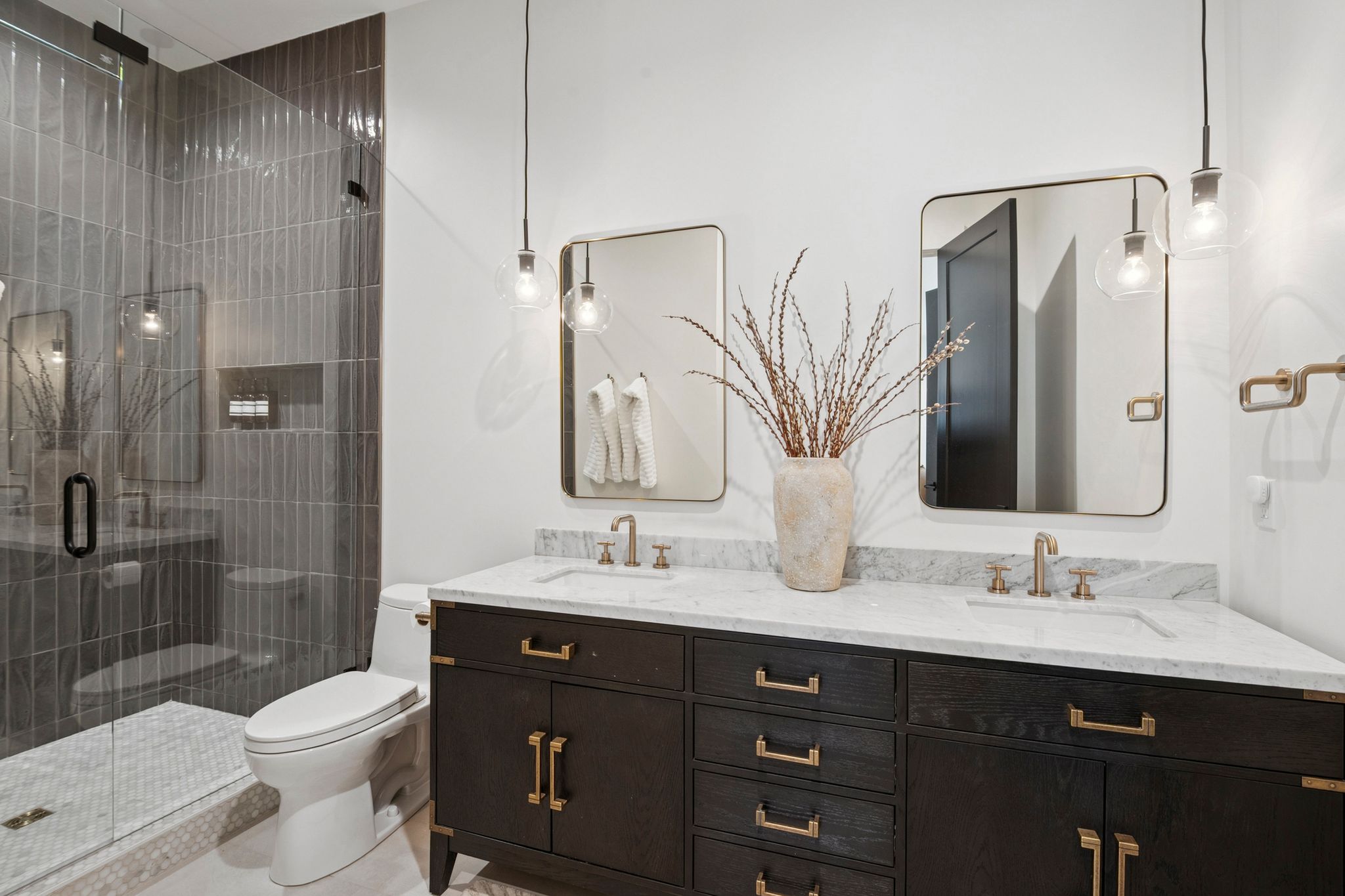 Casita bath featuring dual vanity and luxurious floor to ceiling tile shower with Brizo plumbing fixtures and designer lighting.