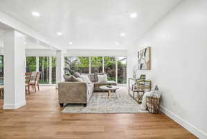 Open-concept living space featuring wood-finish flooring, recessed lighting, and expansive windows