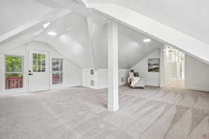 Expansive attic space featuring vaulted ceilings and recessed lighting