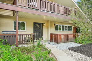 Exterior featuring two levels of wood-railed balconies and a ground-level patio