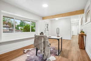 Spacious room featuring wood-finish flooring, a prominent window with white trim, and white painted walls