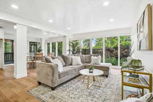 Expansive living area featuring wood-finish flooring, recessed lighting, and abundant natural light from numerous windows