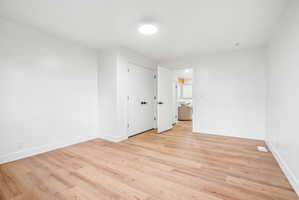 Bright room featuring wood-finish flooring, white painted walls, and white trim