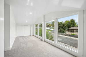 Vaulted ceilings with recessed lighting complement the bright, neutral color palette throughout this space