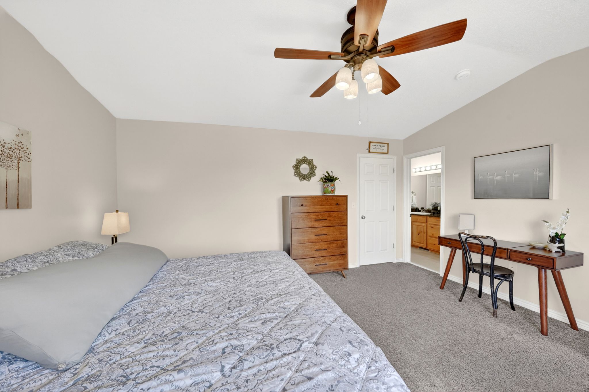 Bedroom featuring vaulted ceiling, light carpet, and ceiling fan