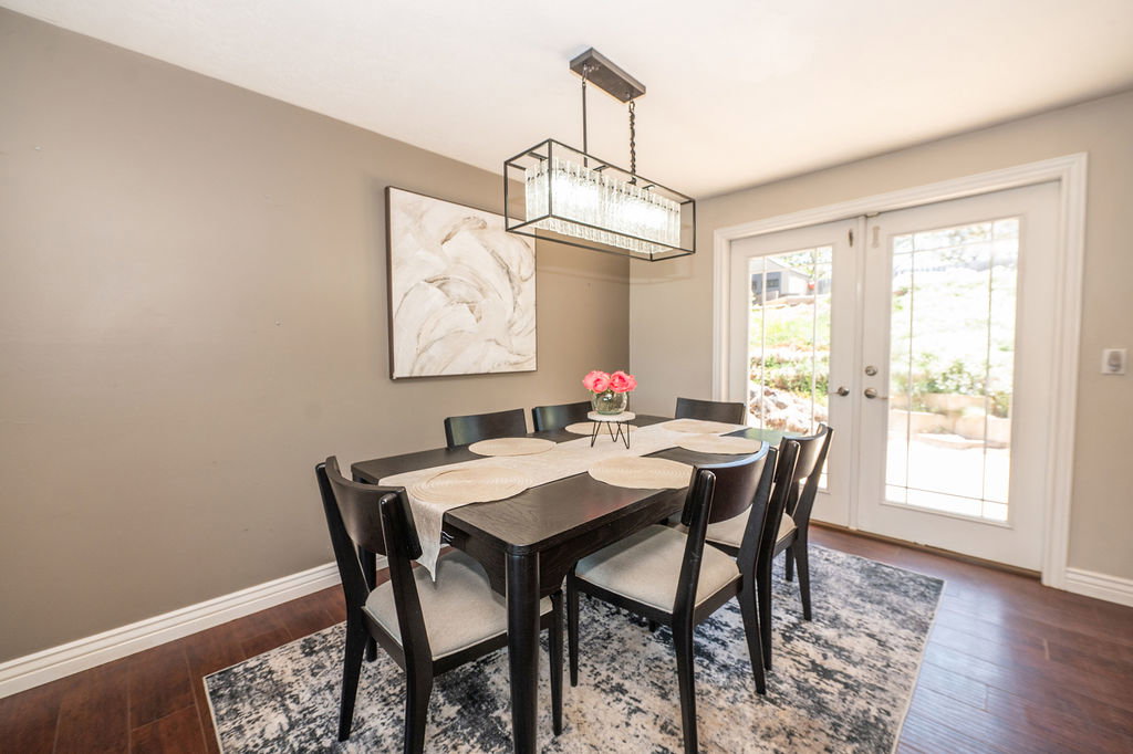 Dining area featuring wood-finish flooring, neutral wall tones, and white trim