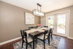 Dining area featuring wood-finish flooring, neutral wall tones, and white trim