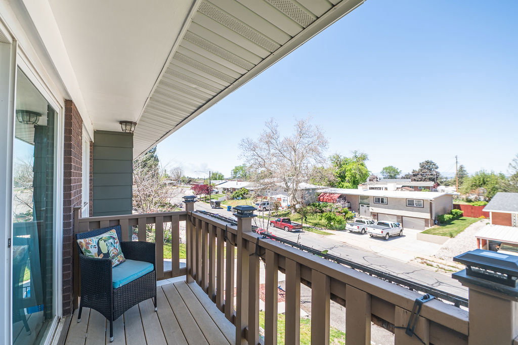 Outdoor balcony featuring wood-finish decking and a robust wood railing