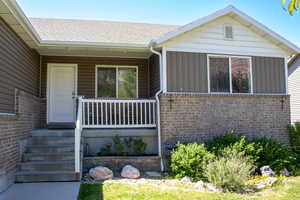 Inviting front porch with concrete steps, white railings, and a solid white entry door