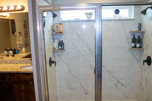 Walk-in shower with clear glass enclosure and light-toned, veined wall surrounds