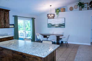 Kitchen island with granite countertop, wood-finish cabinetry, and built-in drawers
