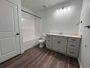 Bathroom featuring a light gray vanity with a single sink, light-toned countertop, and dark hardware