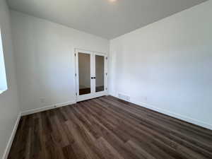 Room with wood-finish flooring and white baseboards