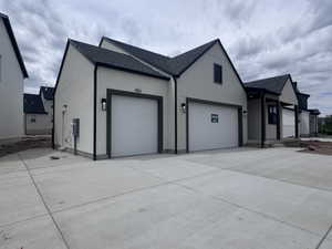 Modern exterior with light stucco siding and dark trim accents