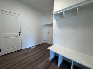 Mudroom featuring wood-finish flooring, white painted walls, a built-in bench, and an overhead shelf