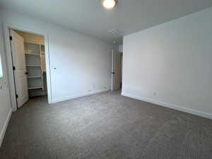 Spacious room with plush gray carpeting, white painted walls, and white trim