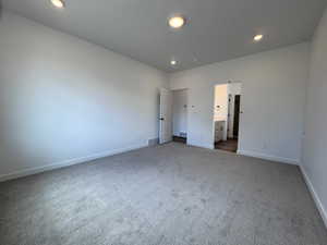 Spacious room featuring neutral carpeting and recessed lighting