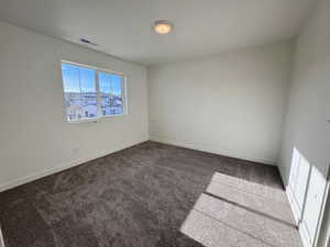 Room featuring neutral wall tones, soft gray carpeting, and a flush-mount ceiling light