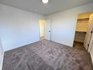 Carpeted room featuring white walls, a white ceiling, and a flush-mount ceiling light