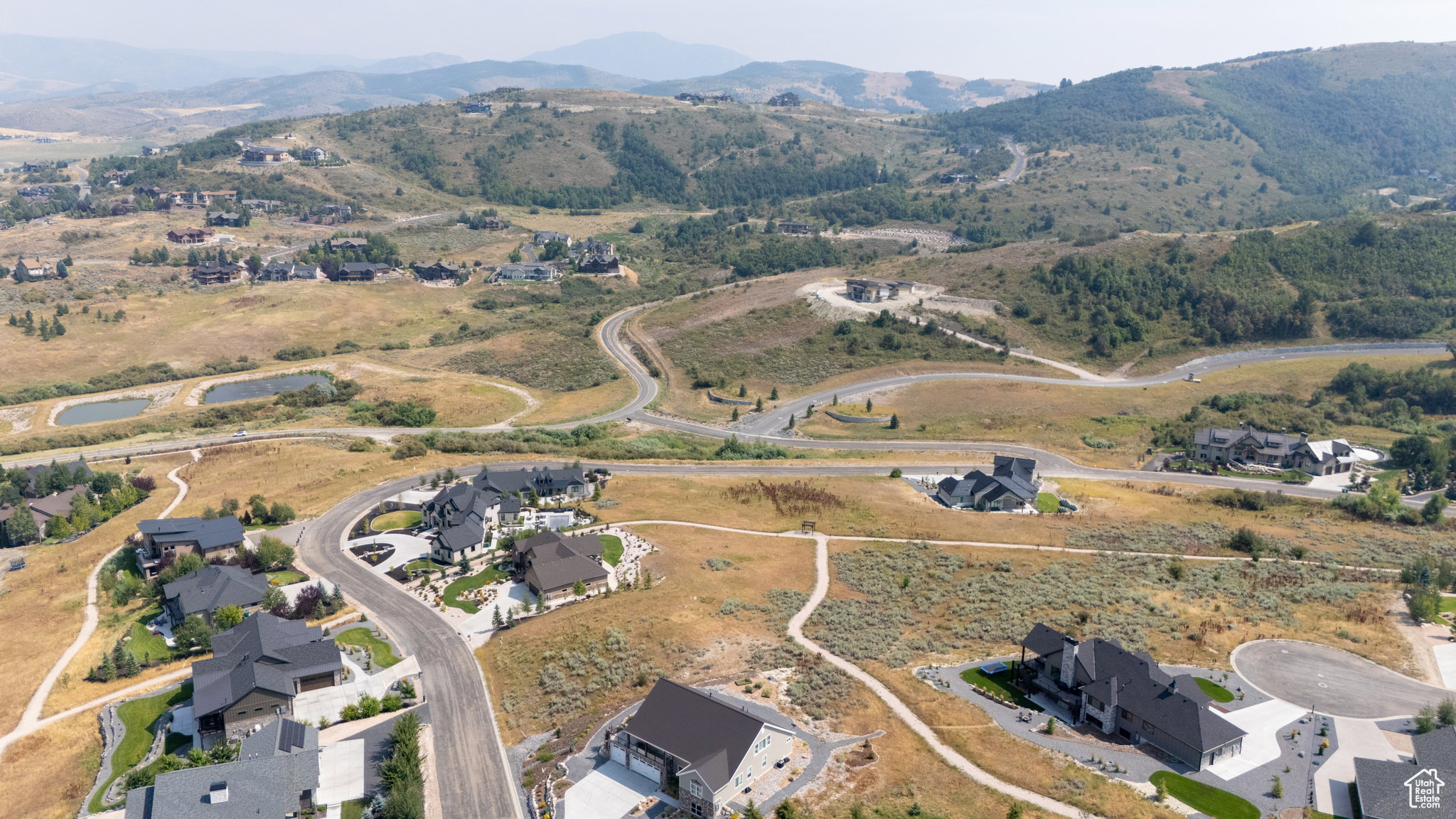 Expansive hillside community featuring multiple modern residences and extensive natural landscaping