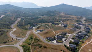 Sprawling mountain landscape featuring extensive paved roadways and numerous residential properties with dark-toned roofs