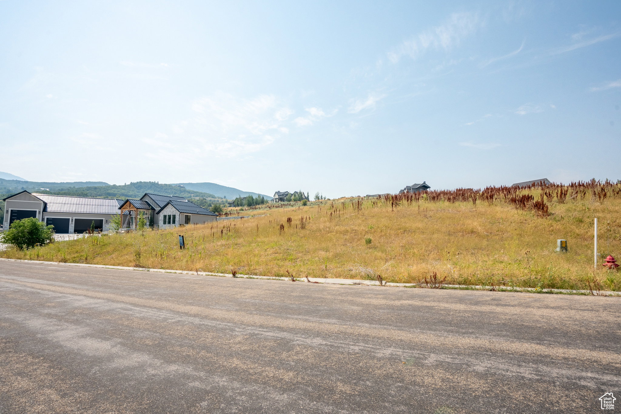 Expansive vacant land offering development opportunity, featuring a gentle upward slope and natural vegetation