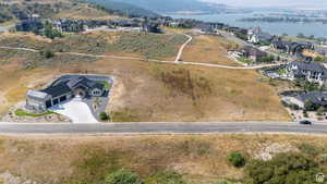 Modern hillside residence featuring a multi-car garage, expansive concrete driveway, and landscaped rock gardens