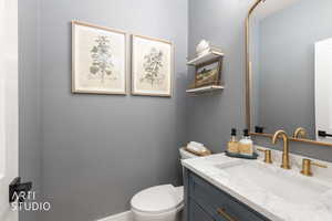 Bathroom vanity with a white countertop and integrated sink, complemented by a gold-finish faucet