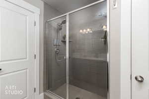 Walk-in shower featuring a glass enclosure with chrome framing, a rain shower head, and a handheld shower wand