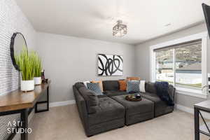 Spacious room featuring light gray walls, plush carpeting, and a large window providing natural light and mountain scenery