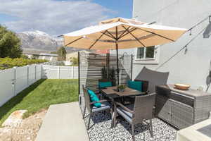 Paved patio area featuring a decorative outdoor rug and a slatted privacy screen