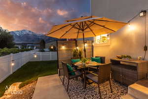 Private patio space featuring string lighting, a decorative privacy screen, and a concrete slab