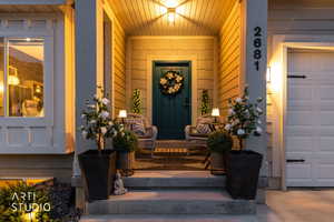 Inviting covered entry featuring a paneled door, vertical siding, and a prominent numerical address