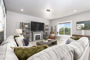 Living area featuring a white trim window, a gray mantel, an electric fireplace insert, and recessed lighting