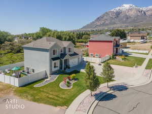 Two-story residence with a light gray facade, attached two-car garage, and a fenced side yard