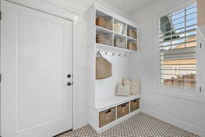 Built-in mudroom bench with cubbies and upper shelving, complete with wall hooks