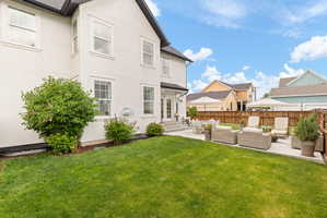 Expansive backyard featuring a lush lawn, a spacious patio, and a privacy fence