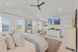 Spacious room featuring vaulted ceilings, a ceiling fan, multiple windows with plantation shutters, recessed lighting, and soft carpet flooring
