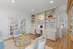 Dedicated workspace featuring extensive built-in shelving, integrated desk, and task lighting