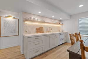 Contemporary wet bar featuring light gray cabinetry, a white countertop, and a tiled backsplash