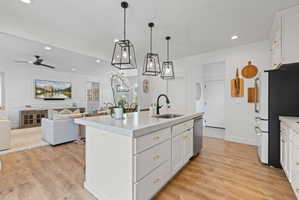 Kitchen island featuring a single-basin sink with a matte black faucet, white cabinetry, and light-toned countertops