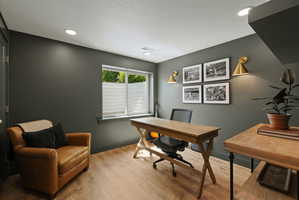 Versatile space featuring wood-finish flooring, recessed lighting, and a large window with privacy blinds