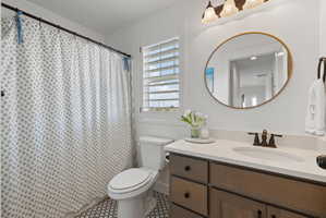 Bathroom featuring a vanity with a light-colored countertop, integrated sink, and dark-finished faucet