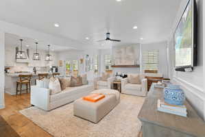 Spacious living area featuring light wood-finish flooring, recessed lighting, and a ceiling fan