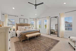 Vaulted ceiling bedroom featuring four windows with white louvered shutters, recessed lighting, a ceiling fan, and carpeted flooring