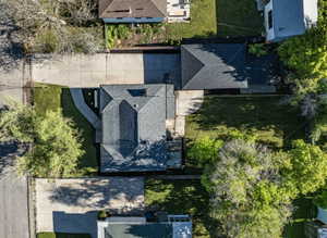 Aerial perspective showcasing a property with a grey shingle roof, established trees, and surrounding green lawns