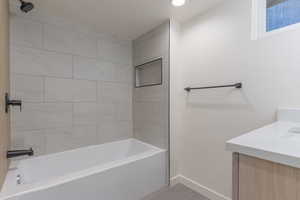 Bathroom featuring a white tub, matte black shower fixtures, light-toned horizontal wall tiling, and a recessed shower niche