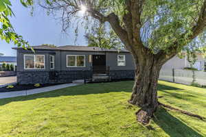Contemporary exterior featuring dark gray siding and a stone-look foundation