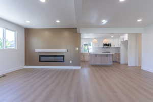 Open-concept living space featuring wood-finish flooring and recessed lighting